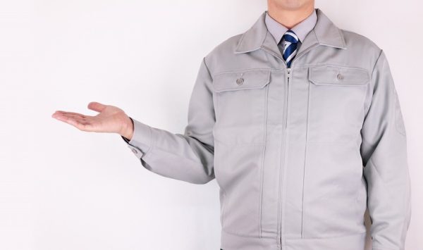 手を横に出している作業服の男性